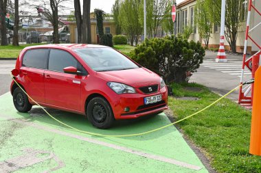 Speyer, Almanya - Nisan 2022: Elektrikli araç bir otoparkta şarj noktasına takıldı