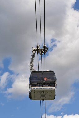 Koblenz, Almanya - Nisan 2022: Ren Nehri üzerindeki bir tepenin üzerindeki Ehrenbreitstein Kalesi 'ne ziyaretçi alan kablo araç.
