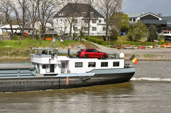 Koblenz, Almanya - Nisan 2022: Moselle Nehri 'ndeki bir sanayi mavnasının arkasındaki köprüyü kapatın. Arka güvertede kaptanın arabası var..