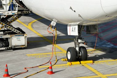 Frankfurt, Almanya - Nisan 2022: Katar Havayolları Boeing 777 jetinin altına bağlı kablolar. Kablolar, uçaklara yerdeyken elektrik sağlıyor..