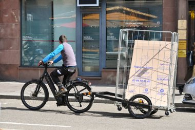Strasbourg, Fransa - Nisan 2022: Strasbourg şehir merkezinde malları teslim etmek için bir karavanı çeken kişi