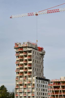Basel, İsviçre - Nisan 2022: Kule vinci yeni bir apartmanın mekanizması üzerinde çalışıyor