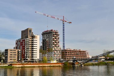 Basel, İsviçre - Nisan 2022: Ren nehrinin kıyısındaki yeni apartman binalarının mekanizması üzerinde çalışan kule vinci
