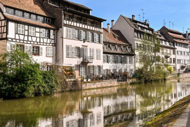 Strasbourg, Fransa - Nisan 2022: Fransa 'nın başkenti yakınlarındaki Tanner' s Quarter of Le Petit France kanalının yanındaki binalar