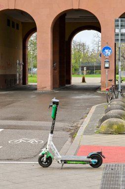 Mannheim, Almanya - Nisan 2022: Elektrik scooter 'ı şehir merkezine yakın bir caddede kaldırımdan sola döndü. Scooter bir kira paylaşım sisteminin parçasıdır..