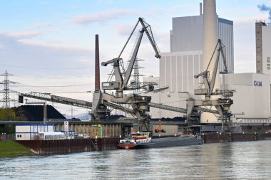 Mannheim, Almanya - Nisan 2022: Ren Nehri 'ndeki bir enerji santralinde endüstriyel bir mavnadan kömür boşaltımı. Fabrika CKM tarafından işletiliyor..