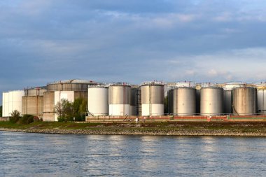 Mannheim, Germany - April 2022: Rows of oil storage tanks on the banks of the River Rhine near Mannheim