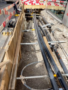 Basel, İsviçre - Nisan 2022: Şehir merkezinde yeni kablolar ve borular döşenmiş uzun bir siper kazıldı.