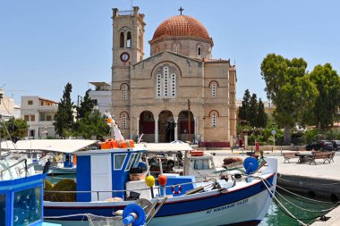 Aegina, Yunanistan, - Mayıs 2022: Arka planda Yunan Ortodoks Kilisesi Isodia Theotokou ile limanda demirlemiş küçük balıkçı tekneleri