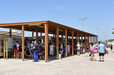 Aegina, Yunanistan, - Mayıs 2022: İnsanlar Aegina adasındaki limandan feribot bileti almak için self servis makinelerini kullanmak için kuyruğa giriyorlar