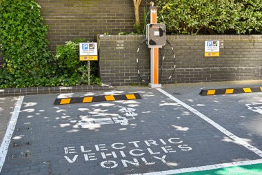 Londra, İngiltere - Haziran 2022: Canary Wharf 'ta elektrikli araçlar için şarj istasyonu bulunan park yeri.