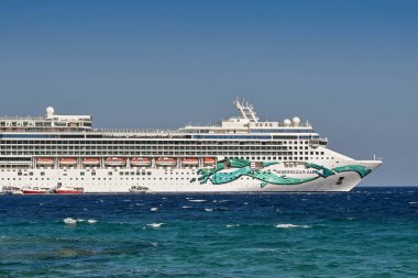 Mykonos, Yunanistan - Haziran 2022: Yunan Adası açıklarında denize demir atmış Norveç Yeşim yolcu gemisinin yan görüntüsü. Gemi NCL tarafından işletiliyor..