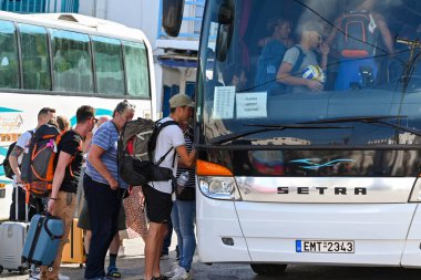 Mykonos, Yunanistan - Haziran 2022: Yunanistan 'ın Mykonos Adası' ndaki otobüs durağındaki havaalanı servis otobüsüne binmek için kalabalık.