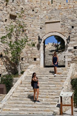 Kusadasi, Türkiye - Haziran 2022: Kusadasi limanındaki Bizans Şatosu girişinde selfie için poz veren ziyaretçi.