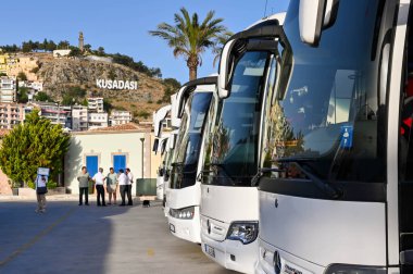 Kusadasi, Türkiye - Haziran 2022: NCL tarafından işletilen Norveç Yeşim yolcu gemisinden indikten sonra rıhtım boyunca yürüyen yolcular.