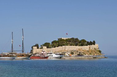 Kusadasi, Türkiye - Haziran 2022: Arka planda Güvercin Adası ile limanda demirlemiş turist botları