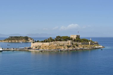 Kusadasi, Turkey - June May 2022: Byzantine Castle on Pigeon Island in the port of Kusadasi.