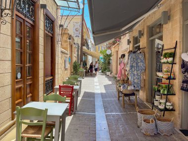 Aegina, Greece - May 2022: Tables outside a restaurant in one of the narrow streets in the island's main town