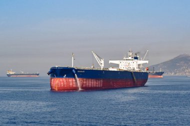 Athens, Greece - May 2022: Large cargo ship at anchor off the coast of Athens awaiting its slot in the city's commercial docks