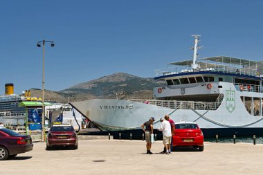 Argostili, Kefalonia, Greece - June 2022: People arriving at the harbour by taxi to catch a ferryin Argostili