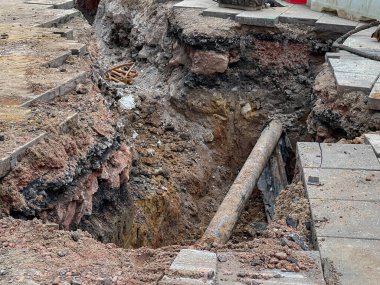 Eski boruları değiştirmek için şehir caddesinde bir çukur kazıldı. Kimse yok..