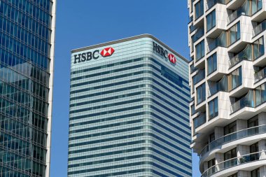 London, England - June 2022: Exterior view of the HSBC office building in Canary Wharf. The view is framed by other office buildings.