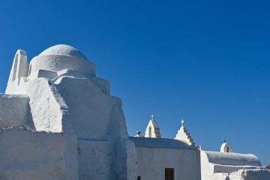 Mykonos, Greece - June 2022: Bell tower of a church on  Mykonos against a deep blue sky. No people.