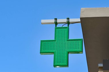 Unbranded sign for a pharmacy against a deep blue sky. No people.