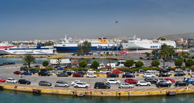 Pire, Atina, Yunanistan - Haziran 2022: Pire limanında feribota binmek için limanda kuyruğa giren arabaların panoramik manzarası ve arka planda diğer feribotlar