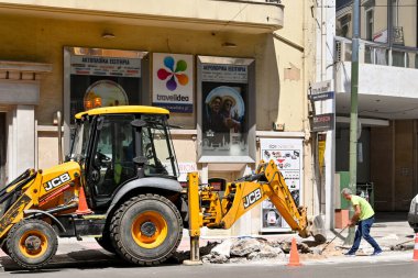 Atina, Yunanistan - Haziran 2022: Bir mekanik kazıcının yardımıyla şehir merkezinde yol kazan kişi