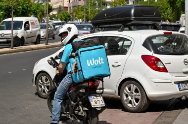 Athens, Greece - May 2022: Container on the back of a motor scooter for delivering take away food. The box is branded with the Wolt partner delivery company. clipart