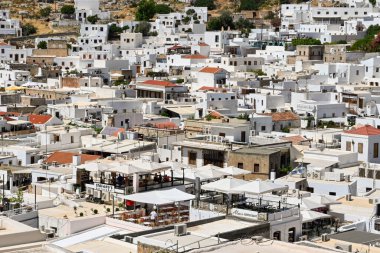 Lindos, Rodes, Greece - May 2022: Aerial view of restaurants and other whitewashed buildings in the town of Lindos