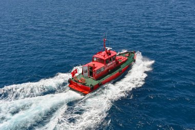 Kusadasi, Turkey - May 2022: Aerial view of a pilot boat leaving a cruise ship after guiding it out of port