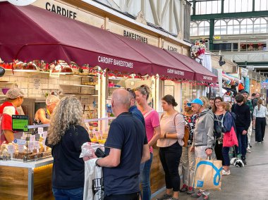 Cardiff, Wales, UK - July 2022: People queuing to buy welsh cakes at one of the stalls in the city's  indoor market