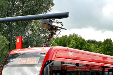Edam, Netherlands - August 2022: Close uop view of an electric bus at the town's bus station recharging its batteries using a rapid overhead charging connection