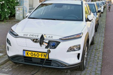 Utrecht, Netherlands - August 2022: Cable plugged in to recharge an electric car