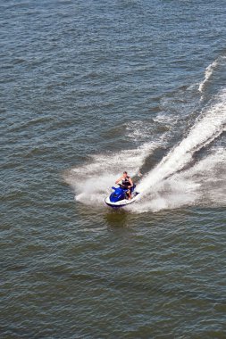 Rotterdam, Netherlands - August 2022: Aerial view of a person riding a fast jet ski on the Nieuwe Maas river, which runs through the centre of the city