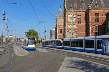 Amsterdam, Netherlands - August 2022: Modern electric tram at a tram stop outside  the city's Centraale railway station