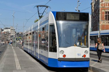 Amsterdam, Netherlands - August 2022: Modern electric tram at a tram stop outside  the city's Centraale railway station