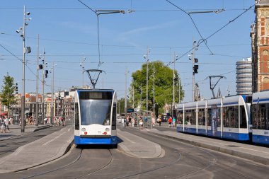 Amsterdam, Netherlands - August 2022: Modern electric tram at a tram stop outside  the city's Centraale railway station
