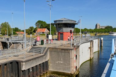 Veere, Netherlands - August 2022: River cruise ship entering the canal lock near the town with lock gate open