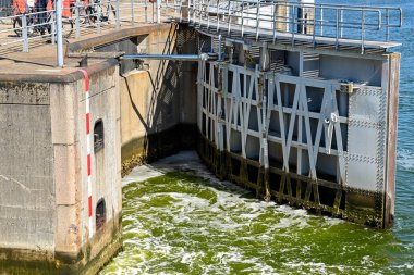 Veere, Netherlands - August 2022: One of the heavy steel gates of the canal lock near the town closing, with swirling water