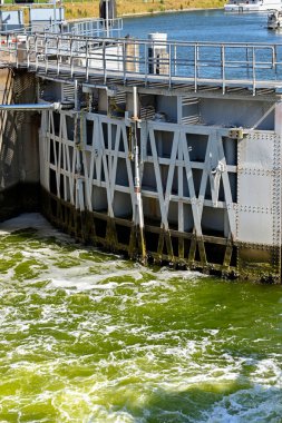 Veere, Netherlands - August 2022: One of the heavy steel gates of the canal lock near the town closing, with swirling water
