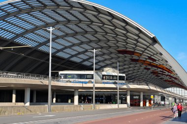 Amsterdam, Netherlands - August 2022: Public service bus entering the bus station under its curved roof at Amsterdam Centraale.
