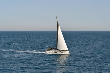 Aegina, Yunanistan - Mayıs 2022: Modern gösterişli yat Aegina adası açıklarında sakin bir denizi aşıyor.