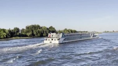 Rotterdam, Hollanda Ağustos 2022: Alacakaranlıkta Nieuwe Maas nehri üzerinde bir turistik nehir yolcu gemisinin yanından geçiyoruz 