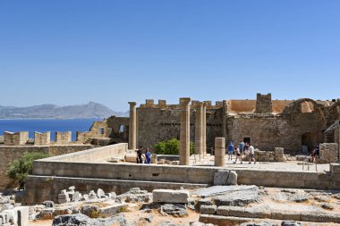 Lindos, Rodos, Yunanistan - Haziran 2022: Lindos 'taki antik akropolün kalıntıları üzerinde yürüyen insanlar