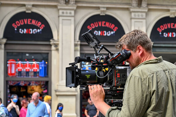 Лондон, Великобритания - июнь 2022: Лицо, использующее профессиональную видеокамеру для съемки телевизионной программы на городской улице