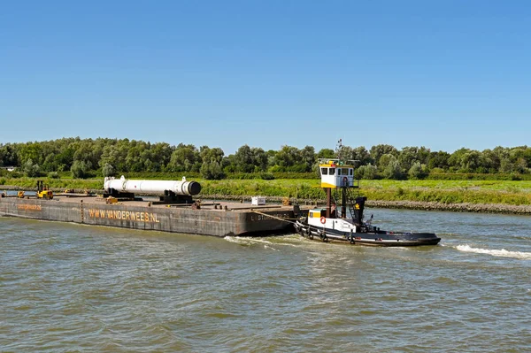 オランダのロッテルダム 2022年8月 ロッテルダム近郊の川にエンジニアリング機器を運ぶ重い貨物船を押すタグ — ストック写真