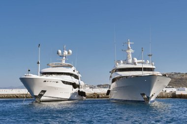Mykonos, Yunanistan - Mayıs 2022: Solda lüks motorlu yatlar Vertigo, sağda Paris Yunanistan 'ın Mykonos adasının limanında demirlemiş durumda.
